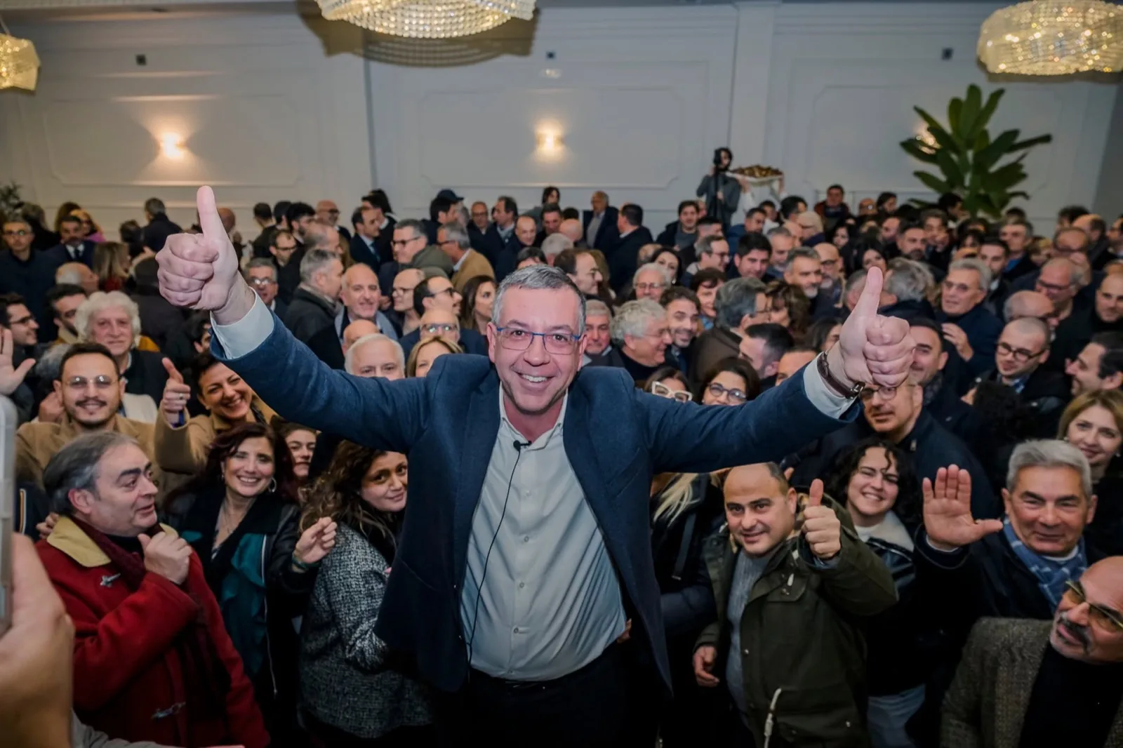 Massimiliano Manfredi festeggia con le braccia alzate insieme a elettrici ed elettori